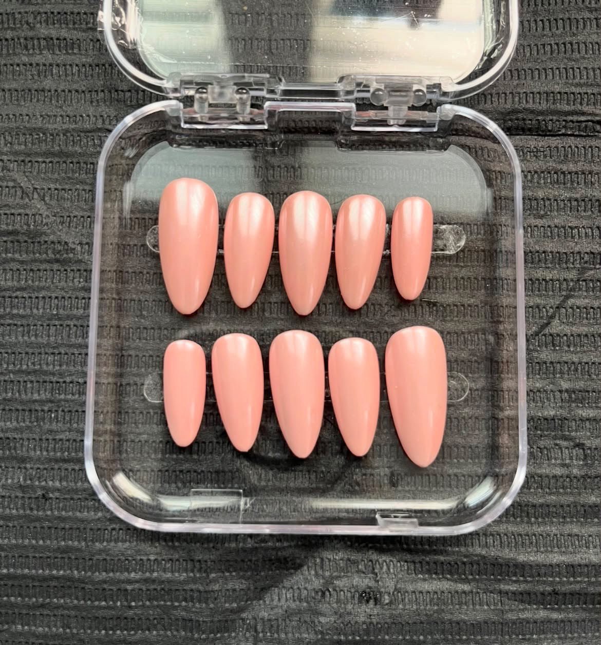 Matte rosé almond nail set in a case